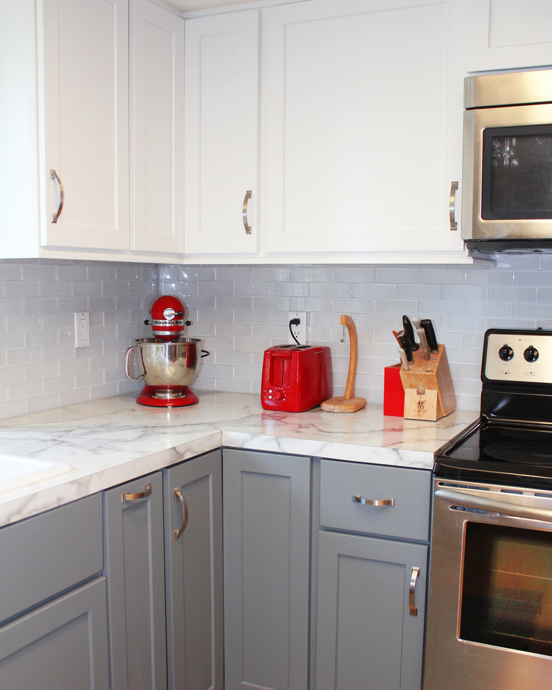 Eat-in kitchen - mid-sized transitional u-shaped bamboo floor eat-in kitchen idea in Boise with a drop-in sink, shaker cabinets, gray cabinets, laminate countertops, white backsplash, glass tile backsplash and stainless steel appliances