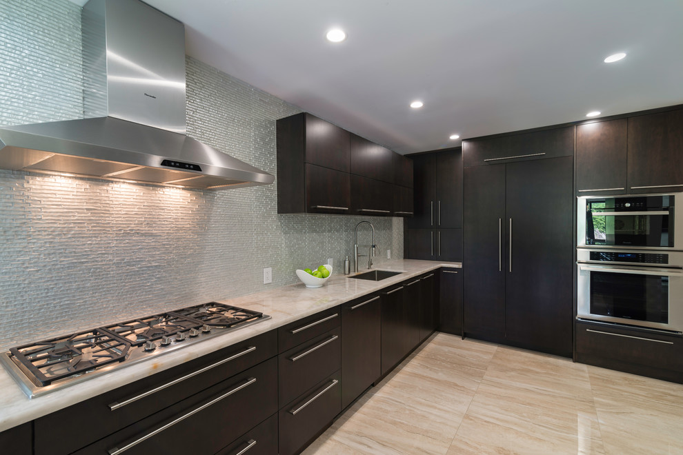 Design ideas for a mid-sized modern l-shaped eat-in kitchen in Miami with flat-panel cabinets, dark wood cabinets, metallic splashback, glass tile splashback, stainless steel appliances and with island.