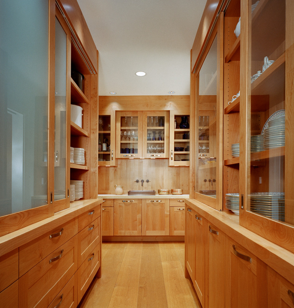 Design ideas for a traditional kitchen in Boston with glass-front cabinets, medium wood cabinets and wood benchtops.