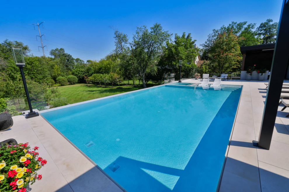 Hot tub - mid-sized backyard stone and rectangular infinity hot tub idea in Chicago
