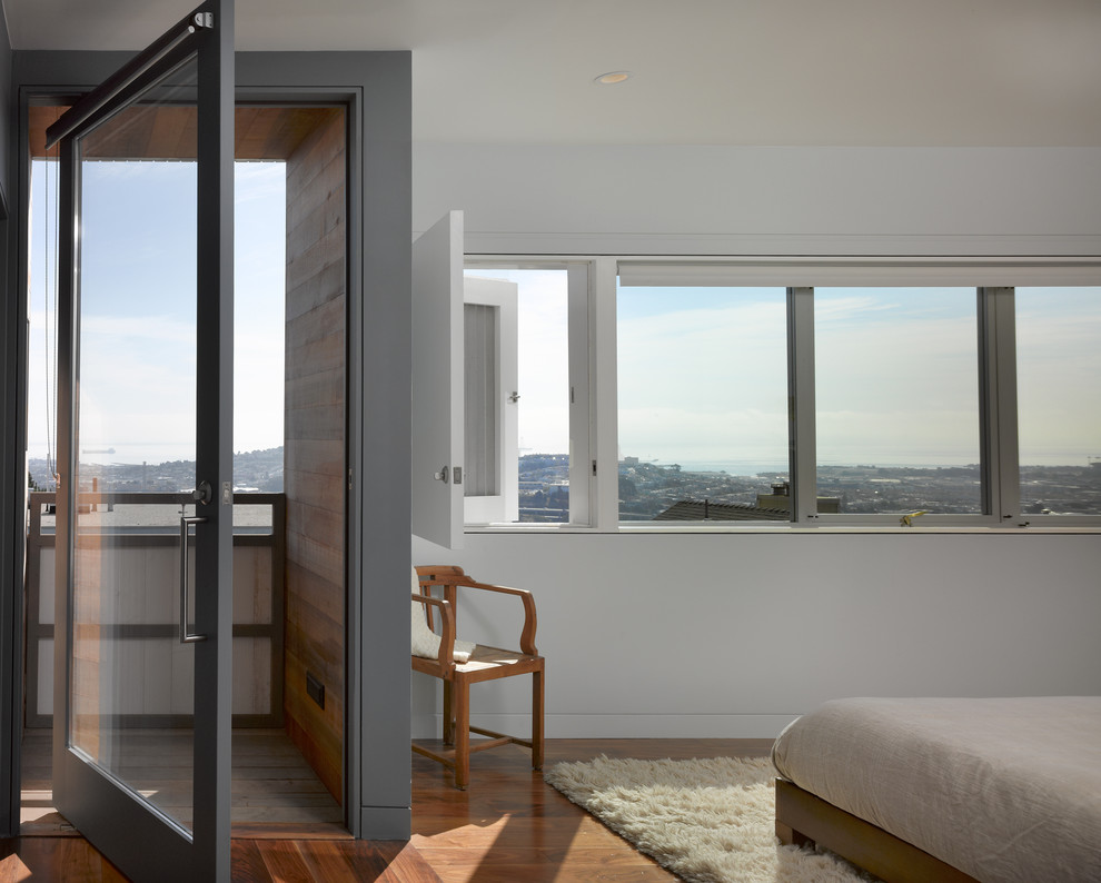 Photo of a modern master bedroom in San Francisco with white walls and medium hardwood floors.