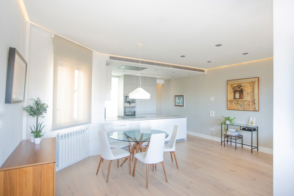 Diseño de comedor de cocina moderno de tamaño medio con paredes blancas, suelo de baldosas de cerámica, todas las chimeneas y suelo marrón