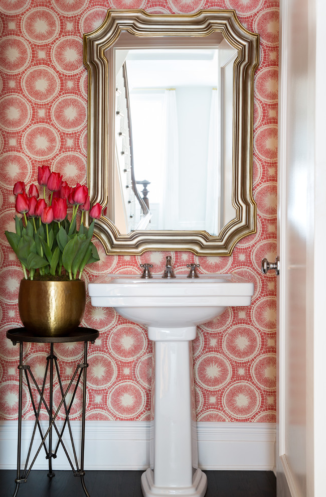 Inspiration for a mid-sized transitional powder room in New York with a pedestal sink, red walls and dark hardwood floors.