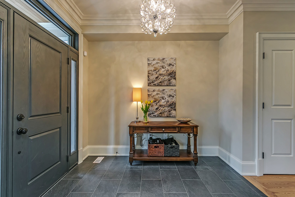 This is an example of a mid-sized traditional foyer in Toronto with grey walls, a single front door, a gray front door, slate floors and grey floor.