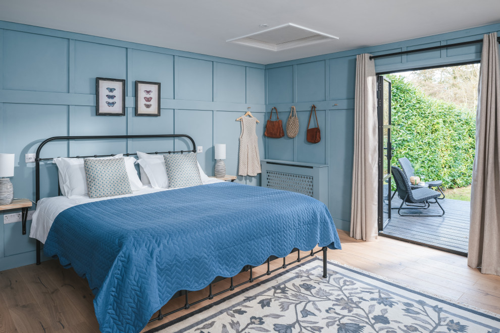 Diseño de dormitorio principal rústico de tamaño medio con paredes azules y suelo de madera clara