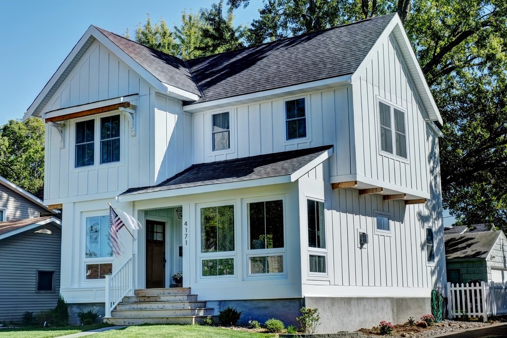 This is an example of a mid-sized country two-storey white exterior in Minneapolis with wood siding and a gable roof.