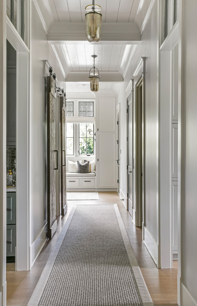 Large cottage medium tone wood floor, brown floor and shiplap ceiling hallway photo in Nashville with gray walls