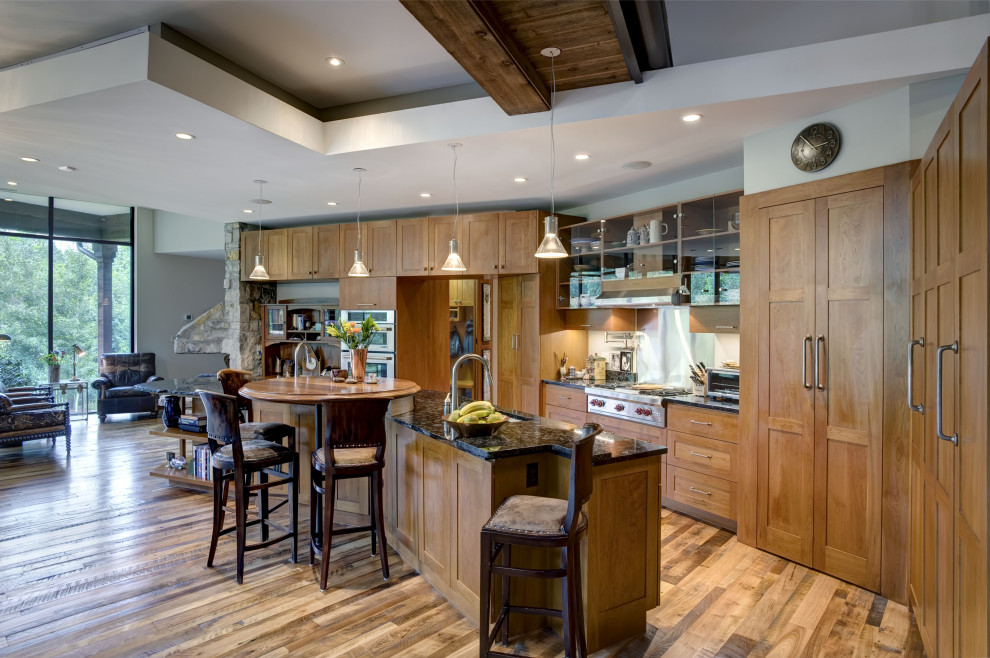 Inspiration for a country open plan kitchen in Other with shaker cabinets, light wood cabinets, metallic splashback, stainless steel appliances, with island and black benchtop.