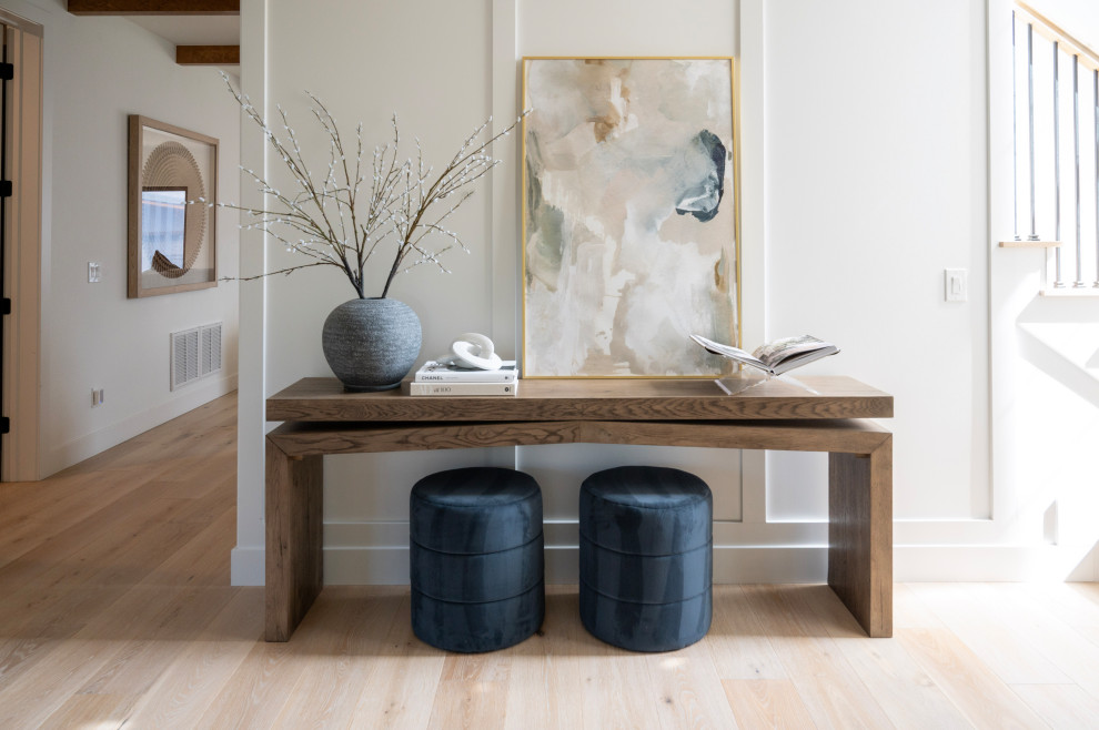 Foyer - transitional light wood floor, beige floor and wall paneling foyer idea in Denver with white walls