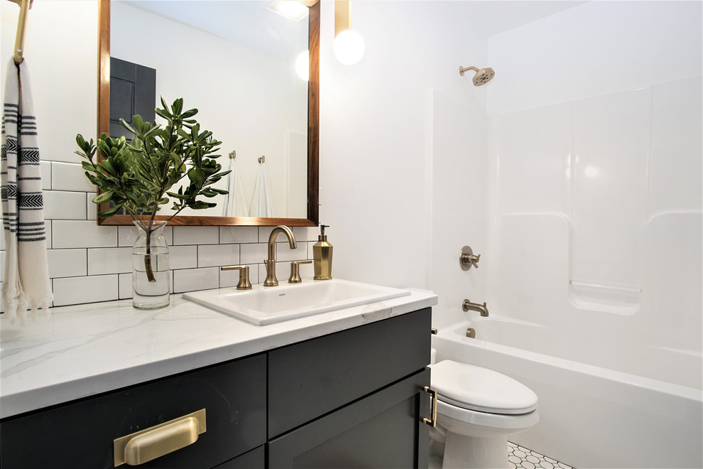 This is an example of a mid-sized scandinavian 3/4 bathroom in Grand Rapids with shaker cabinets, black cabinets, an alcove tub, a shower/bathtub combo, a two-piece toilet, white walls, mosaic tile floors, an undermount sink, quartzite benchtops, white floor, an open shower and white benchtops.