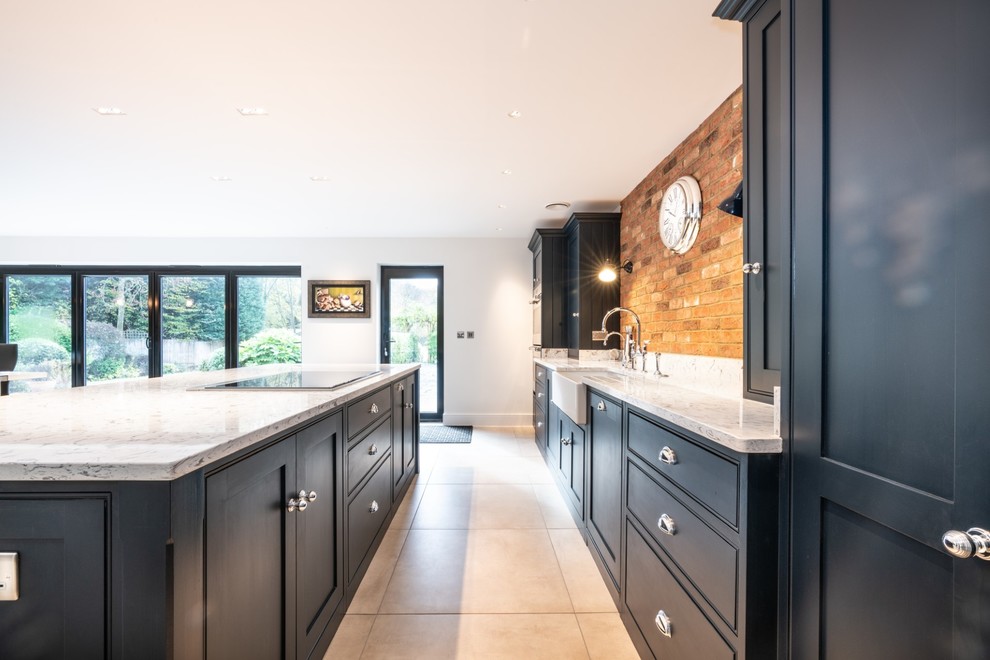 This is an example of an expansive contemporary single-wall open plan kitchen in Essex with a farmhouse sink, beaded inset cabinets, blue cabinets, quartzite benchtops, multi-coloured splashback, brick splashback, stainless steel appliances, terra-cotta floors, with island, beige floor and white benchtop.