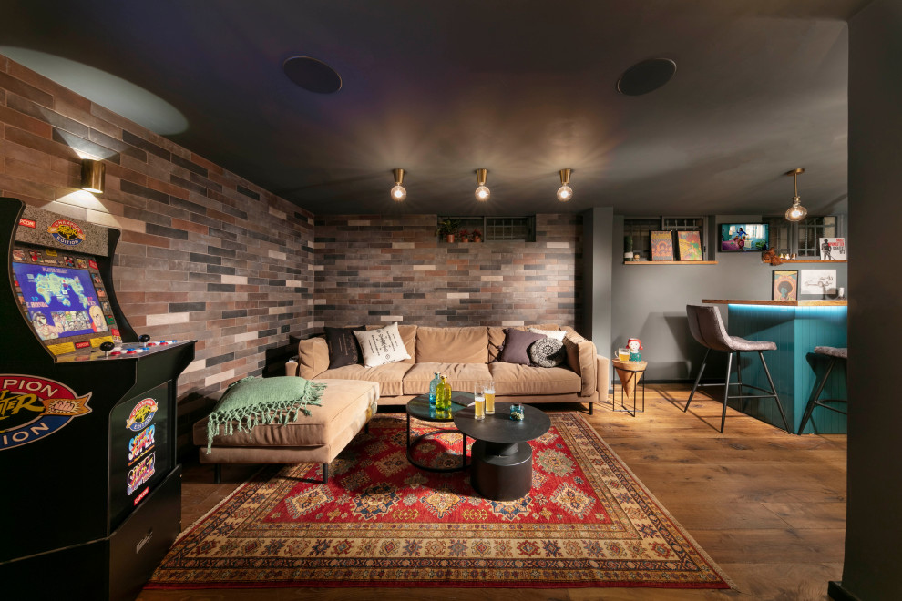 Small industrial look-out basement in Other with a game room, grey walls, medium hardwood flooring, brown floors and brick walls.