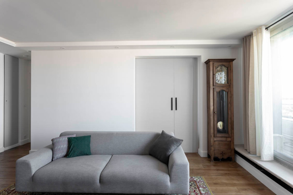 Mittelgroßes, Offenes Modernes Wohnzimmer mit weißer Wandfarbe, braunem Holzboden und braunem Boden in Paris