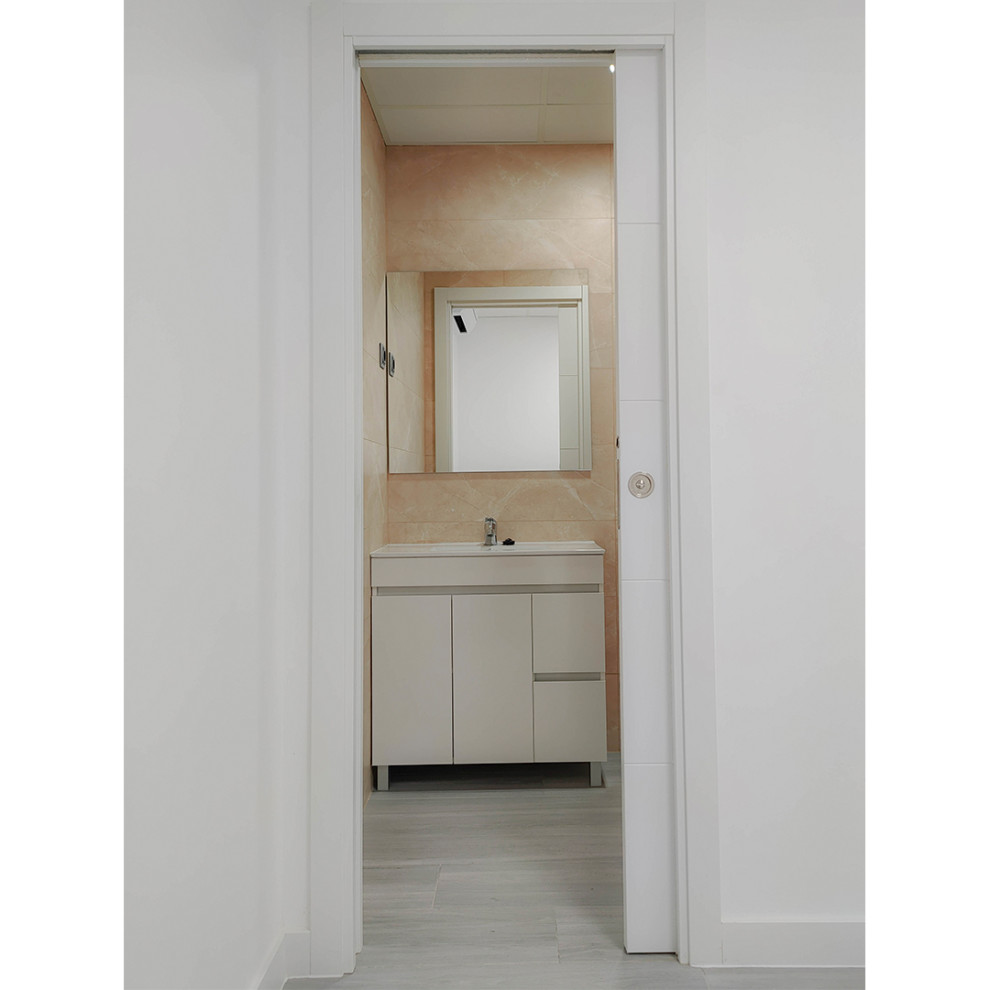 Modelo de aseo a medida minimalista de tamaño medio con puertas de armario blancas, sanitario de dos piezas, baldosas y/o azulejos beige, paredes beige, suelo de madera clara, lavabo encastrado, suelo gris y bandeja