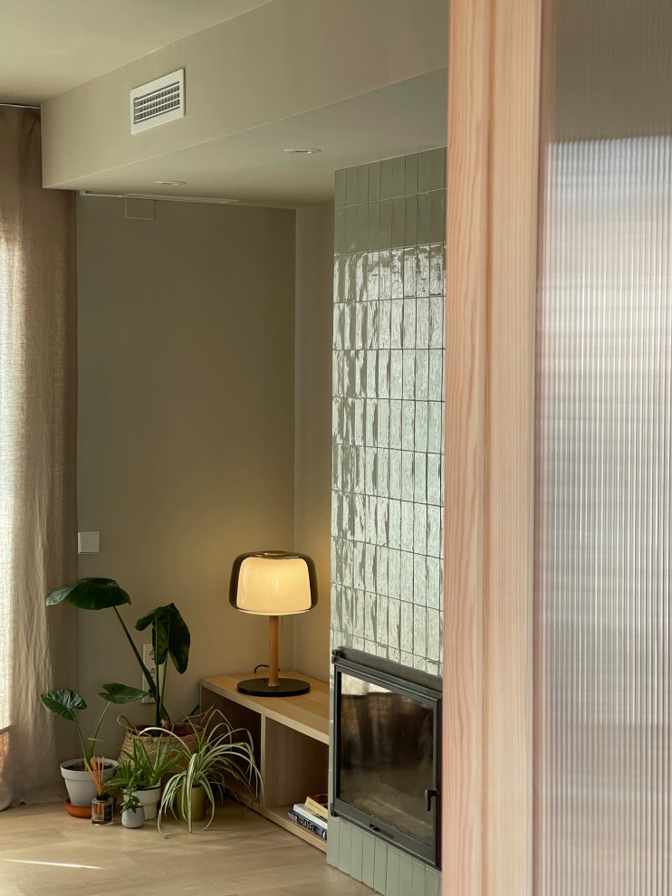 Inspiration pour une grande salle de séjour design ouverte avec un mur vert, sol en stratifié, une cheminée standard et un manteau de cheminée en carrelage.