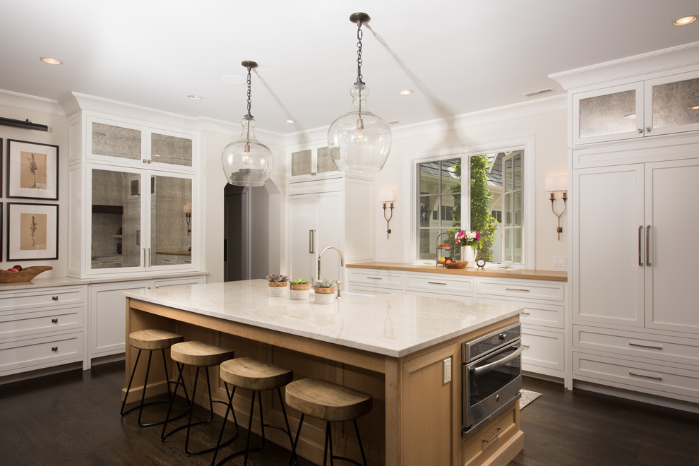 Inspiration for a large traditional kitchen in Chicago with white cabinets, panelled appliances, dark hardwood floors, with island, brown floor and shaker cabinets.