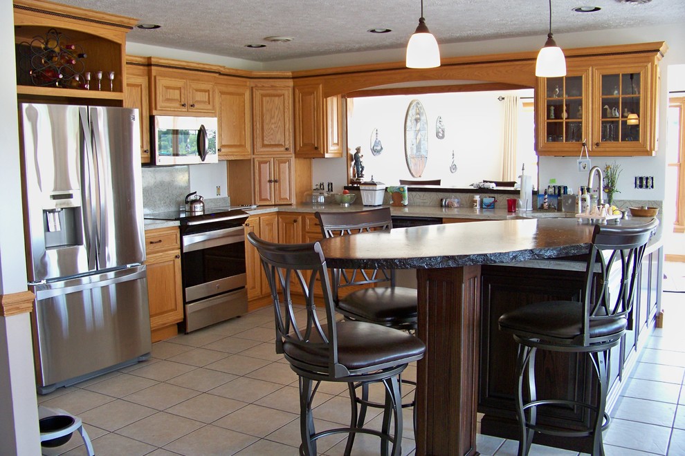 Kitchen - medium tone wood floor kitchen idea with a double-bowl sink, medium tone wood cabinets, granite countertops, beige backsplash and stainless steel appliances