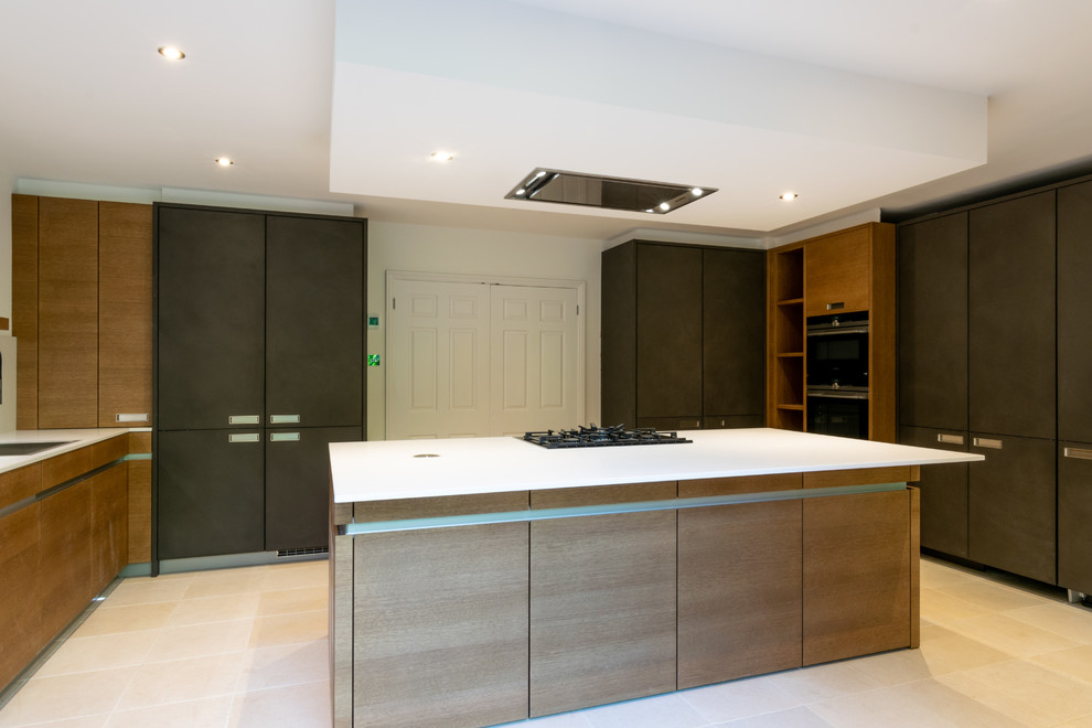 This is an example of a large contemporary u-shaped separate kitchen in Sussex with flat-panel cabinets, grey cabinets, quartzite benchtops, white splashback, limestone floors, with island, beige floor and white benchtop.