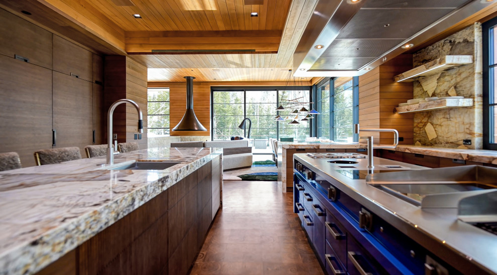 This is an example of a large modern open plan kitchen in Salt Lake City with an undermount sink, glass-front cabinets, medium wood cabinets, marble benchtops, multi-coloured splashback, marble splashback, stainless steel appliances, medium hardwood floors, multiple islands, brown floor, multi-coloured benchtop and wood.