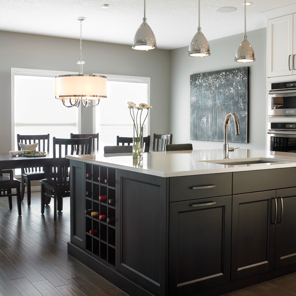 Eat-in kitchen - mid-sized transitional l-shaped dark wood floor eat-in kitchen idea in Calgary with an undermount sink, shaker cabinets, white cabinets, quartzite countertops, multicolored backsplash, matchstick tile backsplash, stainless steel appliances and an island