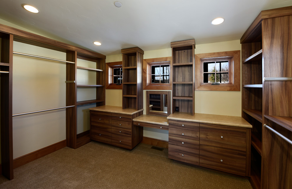 Example of a large transitional carpeted and brown floor walk-in closet design with flat-panel cabinets and medium tone wood cabinets
