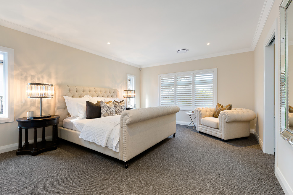 Large contemporary master bedroom in Sydney with beige walls and carpet.