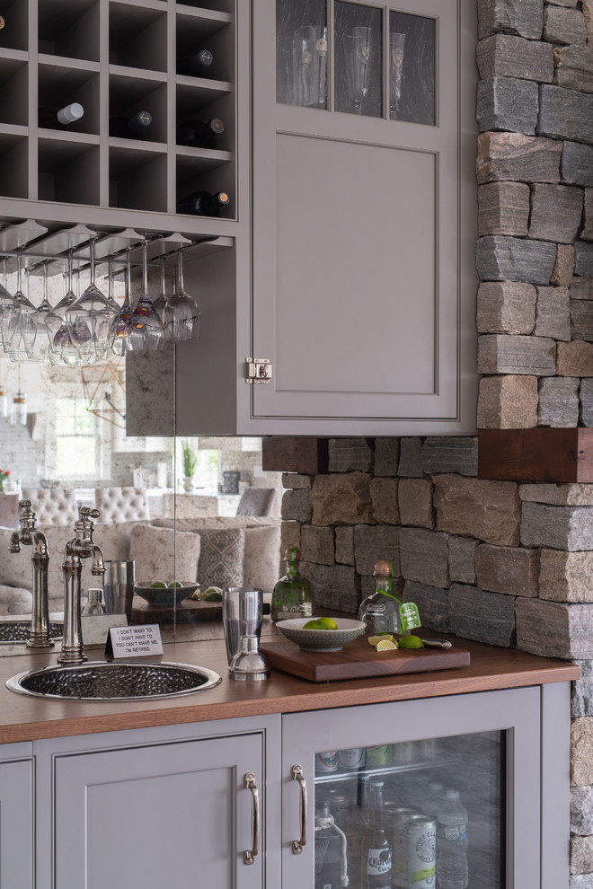 Transitional home bar in Boston with a drop-in sink, beaded inset cabinets, grey cabinets, wood benchtops, mirror splashback, medium hardwood floors, brown floor and brown benchtop.