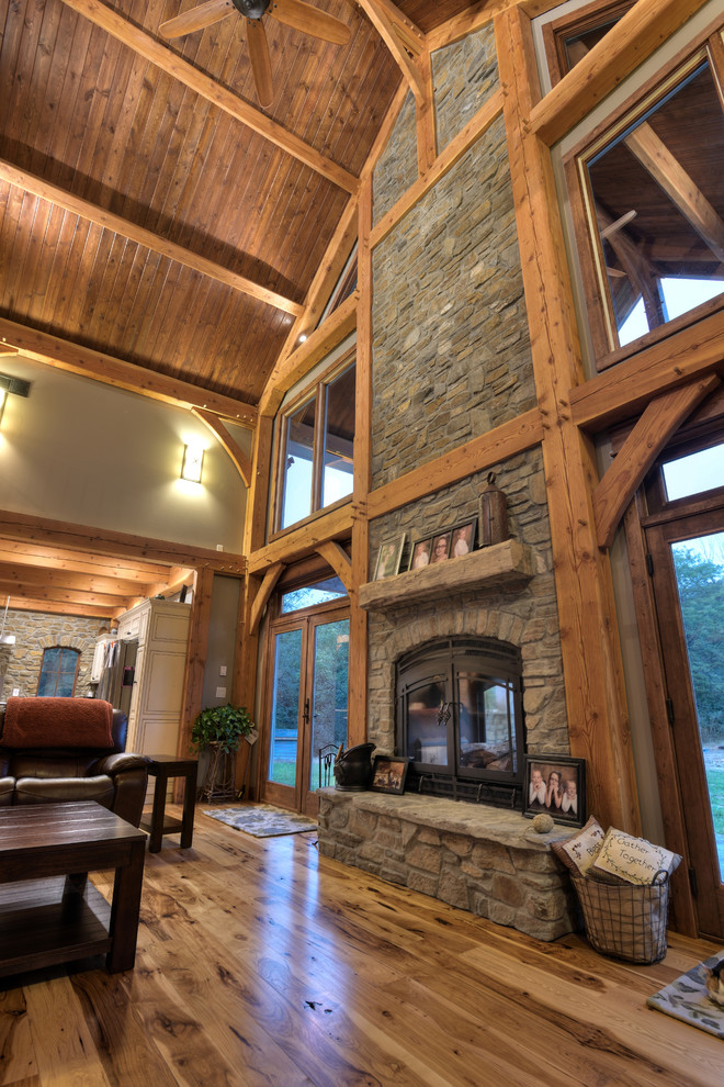 Inspiration for a large traditional open concept family room in Seattle with beige walls, light hardwood floors, a two-sided fireplace, a stone fireplace surround and no tv.