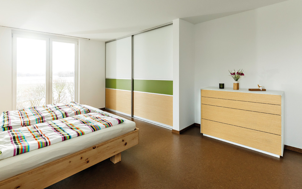 Photo of a large contemporary master bedroom in Stuttgart with white walls, cork floors and brown floor.