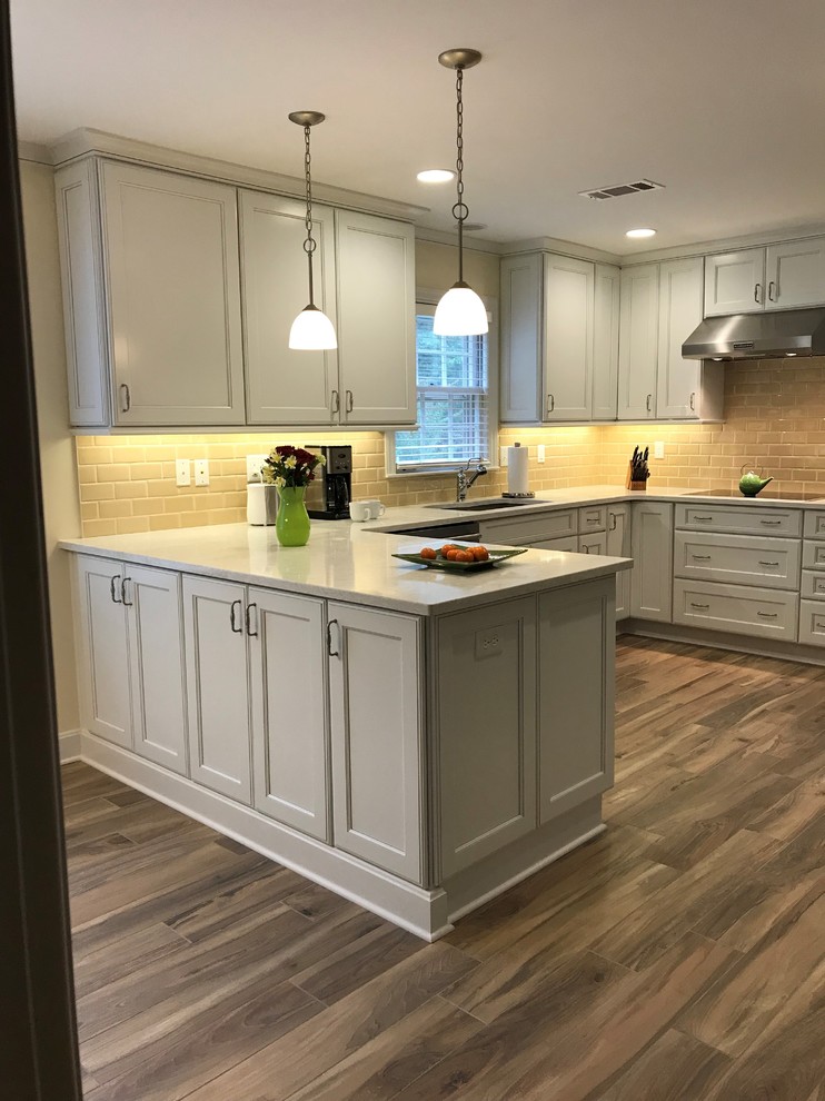 Example of a mid-sized galley porcelain tile and beige floor eat-in kitchen design in Other with an undermount sink, recessed-panel cabinets, white cabinets, quartz countertops, beige backsplash, ceramic backsplash, stainless steel appliances, no island and yellow countertops