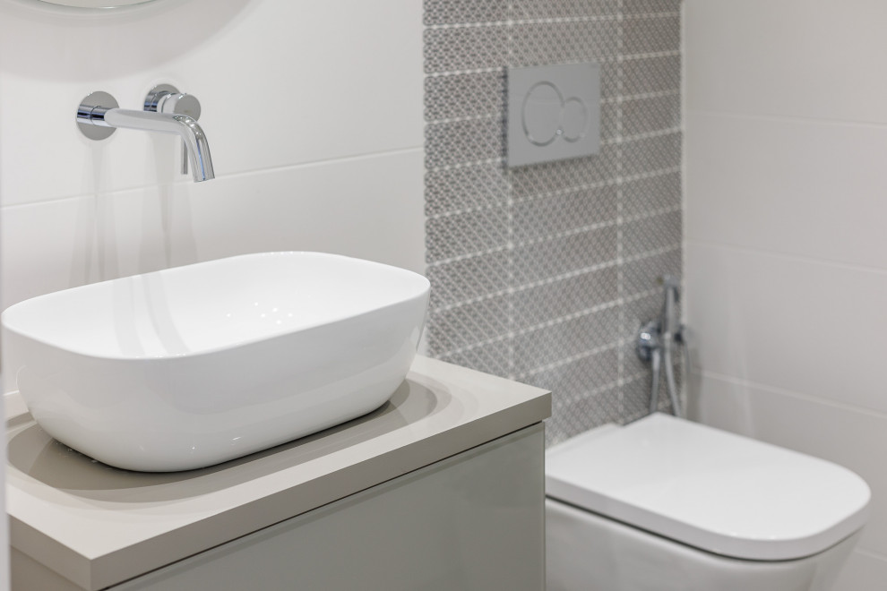 Medium sized classic cloakroom in Valencia with flat-panel cabinets, grey cabinets, a wall mounted toilet, white tiles, mosaic tiles, white walls, porcelain flooring, a vessel sink, wooden worktops, grey floors, grey worktops and a floating vanity unit.