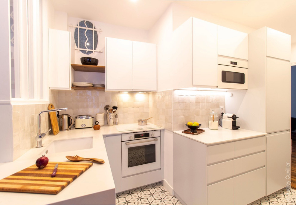 Idéer för att renovera ett litet vintage vit vitt kök, med en undermonterad diskho, vita skåp, bänkskiva i kvartsit, vitt stänkskydd, stänkskydd i keramik, vita vitvaror, cementgolv och grått golv