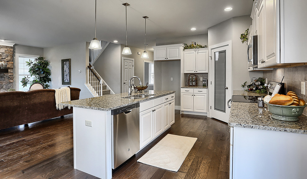 Large transitional medium tone wood floor eat-in kitchen photo with a double-bowl sink, white cabinets, granite countertops, gray backsplash, ceramic backsplash, stainless steel appliances and an island