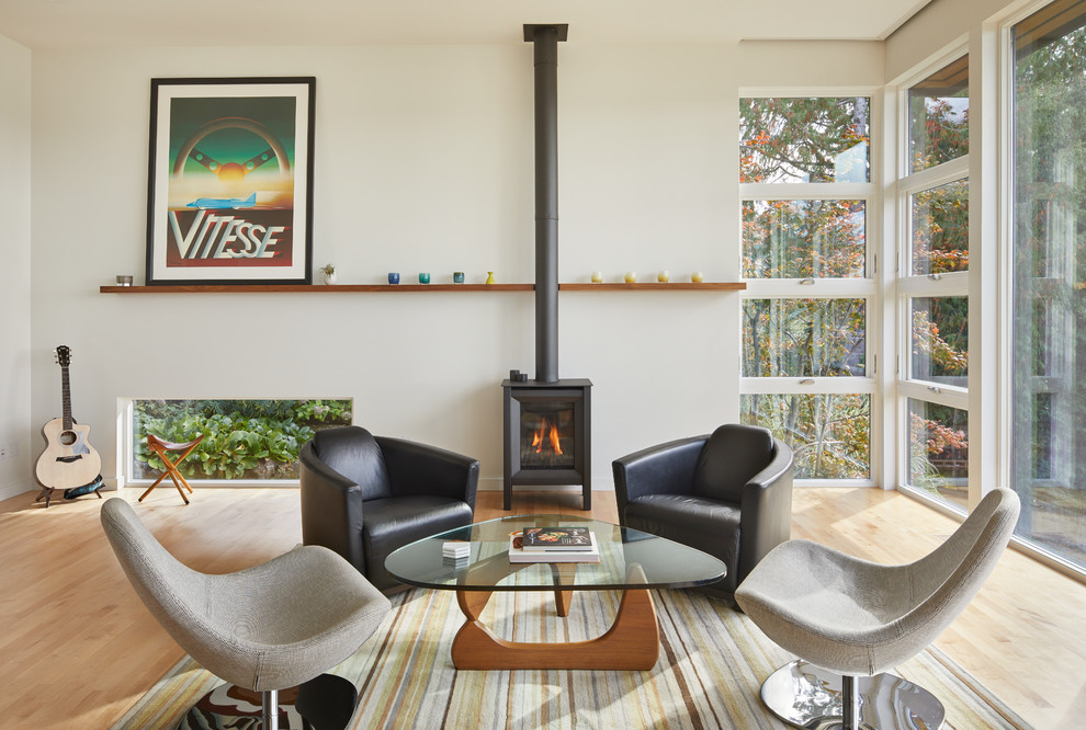 Inspiration for a mid-sized midcentury open concept living room in Seattle with white walls, light hardwood floors and a wood stove.