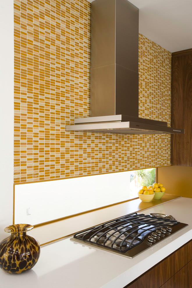 Photo of a mid-sized midcentury l-shaped eat-in kitchen in Los Angeles with an undermount sink, flat-panel cabinets, medium wood cabinets, quartz benchtops, beige splashback, mosaic tile splashback, panelled appliances and with island.