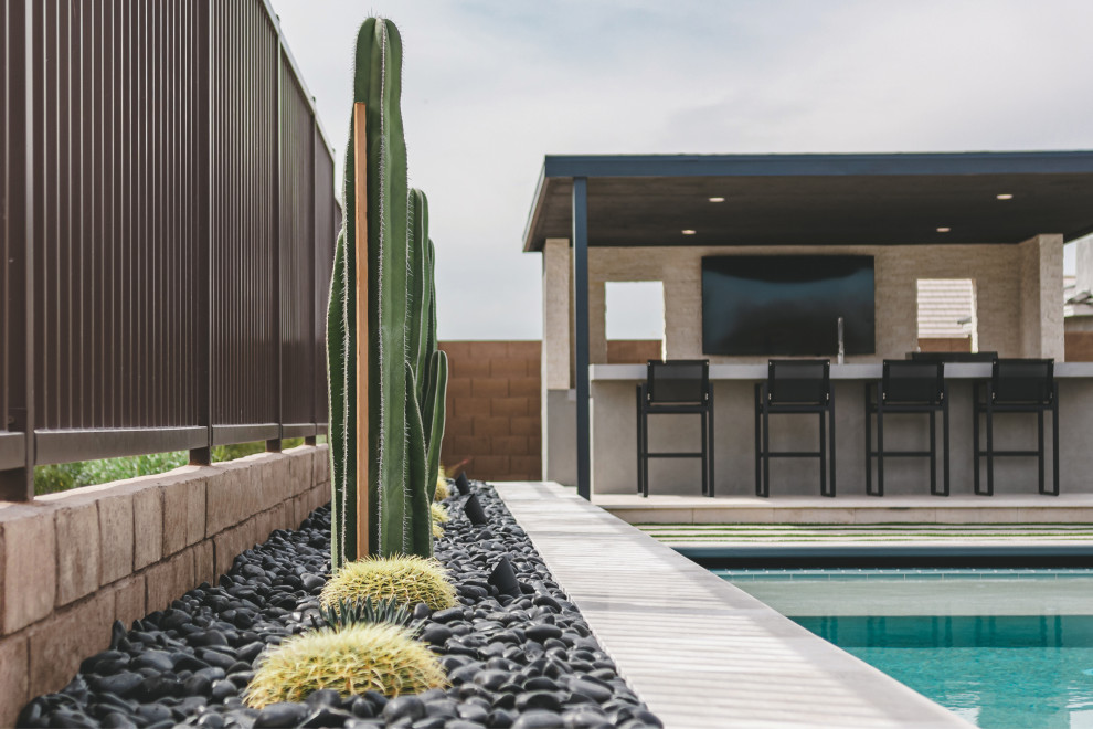 Inspiration for a modern backyard rectangular pool in Phoenix with a pool house and natural stone pavers.