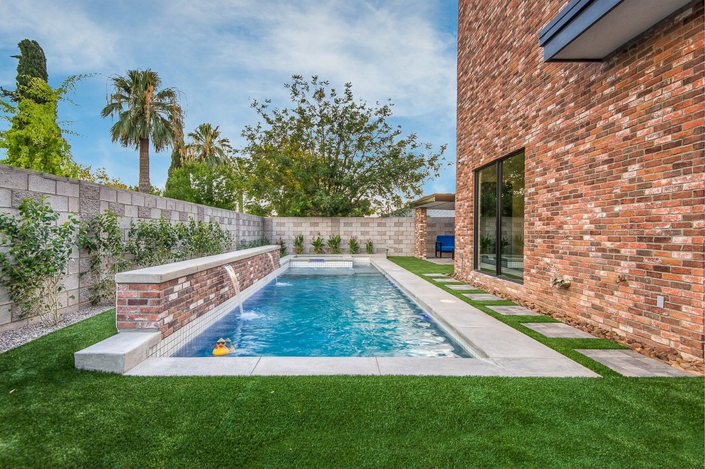 Small modern side yard rectangular pool in Phoenix with a water feature and concrete slab.