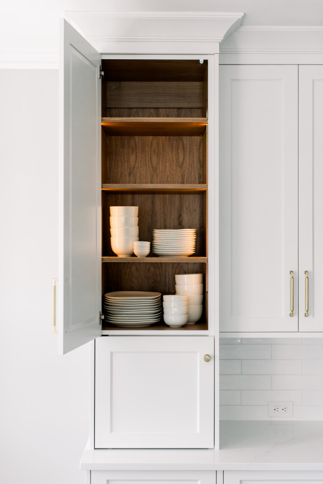 Eat-in kitchen - mid-sized transitional single-wall dark wood floor, brown floor and exposed beam eat-in kitchen idea with an undermount sink, shaker cabinets, white cabinets, quartz countertops, white backsplash, subway tile backsplash, stainless steel appliances, an island and white countertops