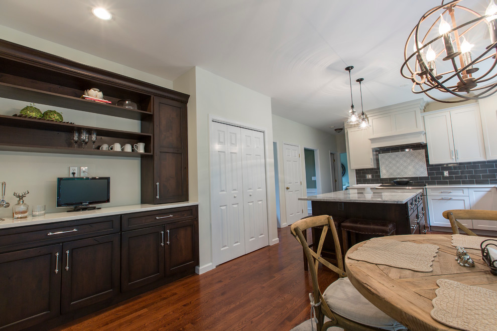 Mid-sized transitional l-shaped medium tone wood floor eat-in kitchen photo in Bridgeport with an undermount sink, recessed-panel cabinets, gray cabinets, granite countertops, black backsplash, ceramic backsplash, stainless steel appliances and an island