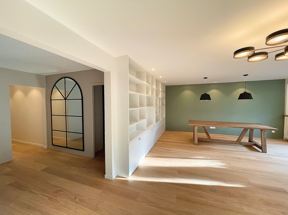 Modelo de salón abierto actual extra grande con suelo de madera clara