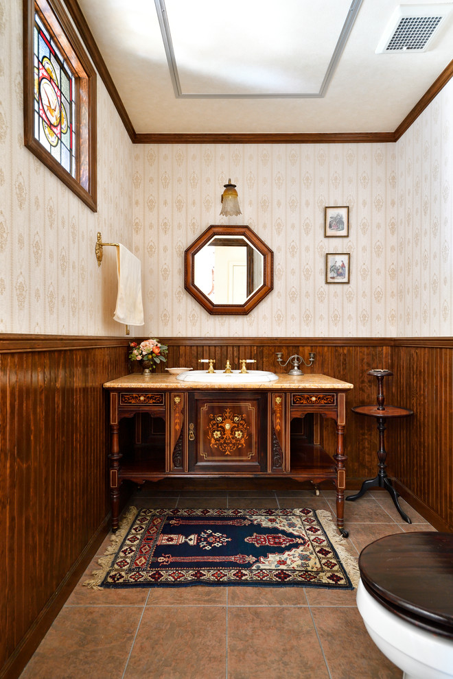 Inspiration for a large traditional powder room in Tokyo Suburbs with furniture-like cabinets, dark wood cabinets, a two-piece toilet, beige walls, porcelain floors, a drop-in sink, onyx benchtops, pink floor and orange benchtops.