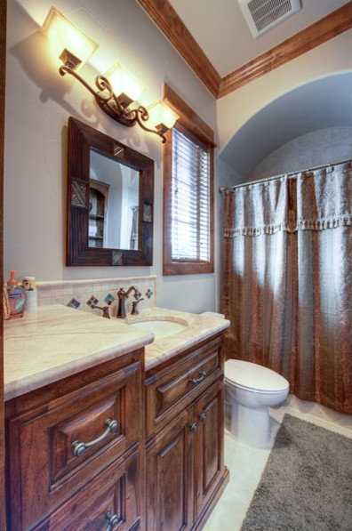 Design ideas for a country bathroom in Austin with an undermount sink and medium wood cabinets.