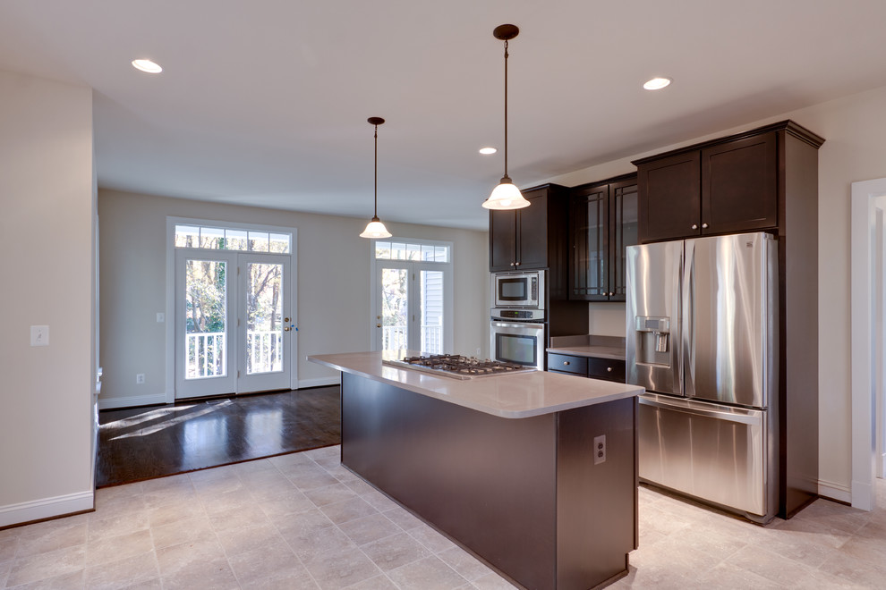 L-shaped ceramic tile eat-in kitchen photo in DC Metro with an undermount sink, shaker cabinets, dark wood cabinets, quartz countertops, stainless steel appliances and an island