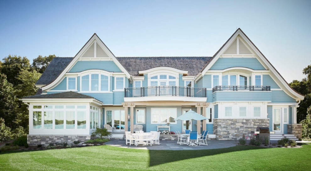 Стильный дизайн: большой, двухэтажный, синий частный загородный дом в морском стиле с комбинированной облицовкой, крышей из гибкой черепицы и черной крышей - последний тренд