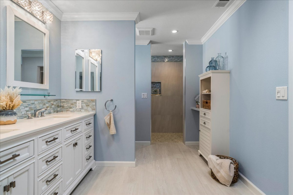 Large nautical ensuite bathroom in San Francisco with freestanding cabinets, white cabinets, a walk-in shower, a two-piece toilet, porcelain tiles, blue walls, porcelain flooring, a submerged sink, solid surface worktops, beige floors, an open shower, white worktops, a shower bench, double sinks, a built in vanity unit and multi-coloured tiles.