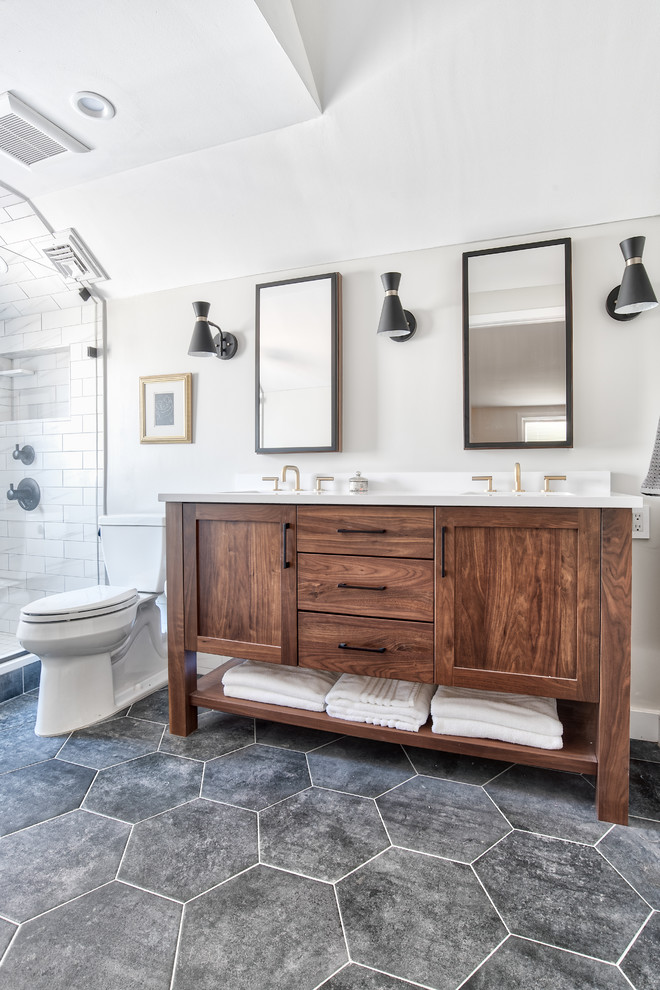 This is an example of a mid-sized modern master bathroom in New York with shaker cabinets, medium wood cabinets, an alcove shower, a two-piece toilet, white tile, beige walls, porcelain floors, an undermount sink, quartzite benchtops, black floor, a hinged shower door and white benchtops.