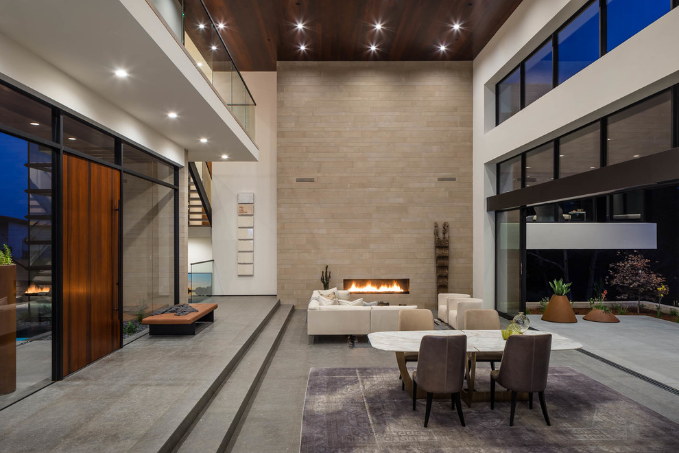Photo of a contemporary living room in San Francisco with white walls, concrete floors, a ribbon fireplace, a tile fireplace surround and grey floor.
