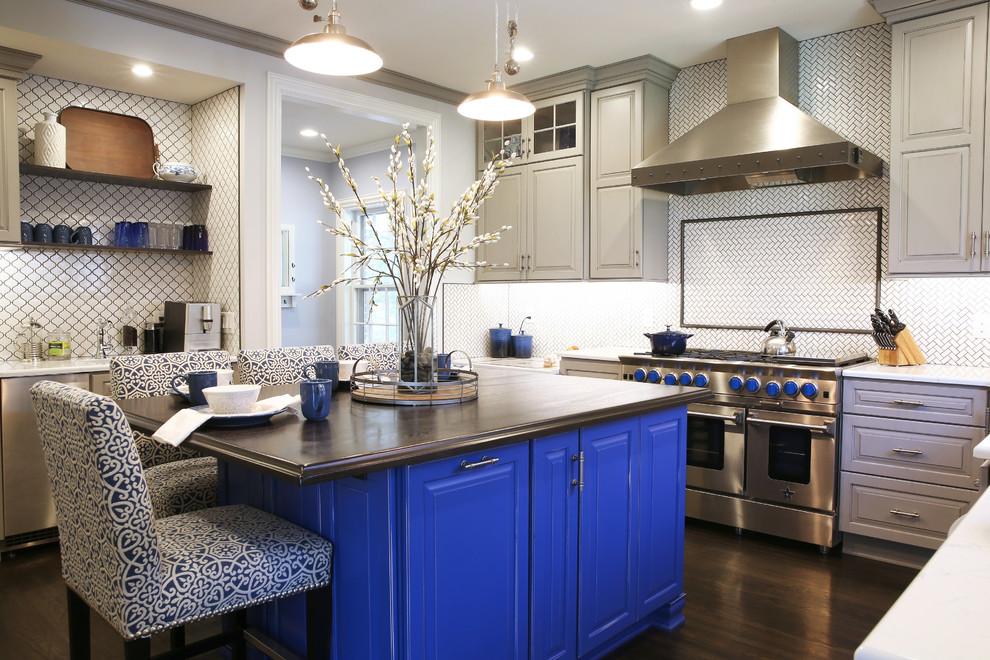 Large transitional l-shaped dark wood floor and brown floor enclosed kitchen photo with an island, raised-panel cabinets, white backsplash, ceramic backsplash and stainless steel appliances