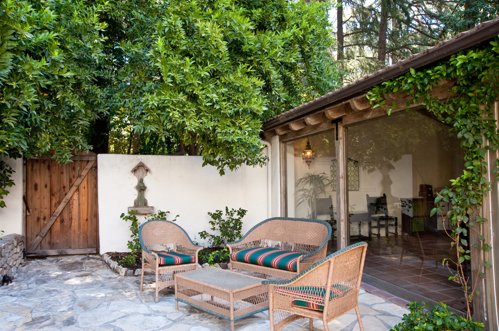 This is an example of a mediterranean patio in Los Angeles with natural stone pavers and no cover.