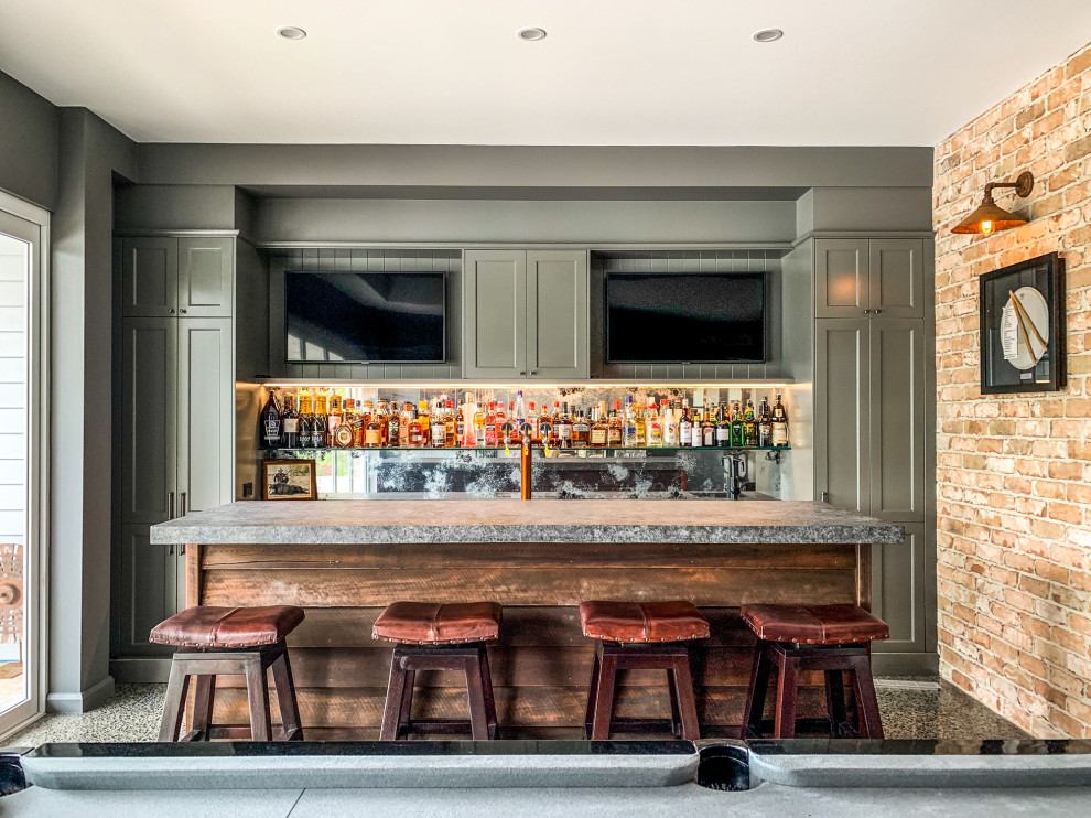 This is an example of a transitional galley seated home bar in Sunshine Coast with shaker cabinets, green cabinets, mirror splashback and grey benchtop.